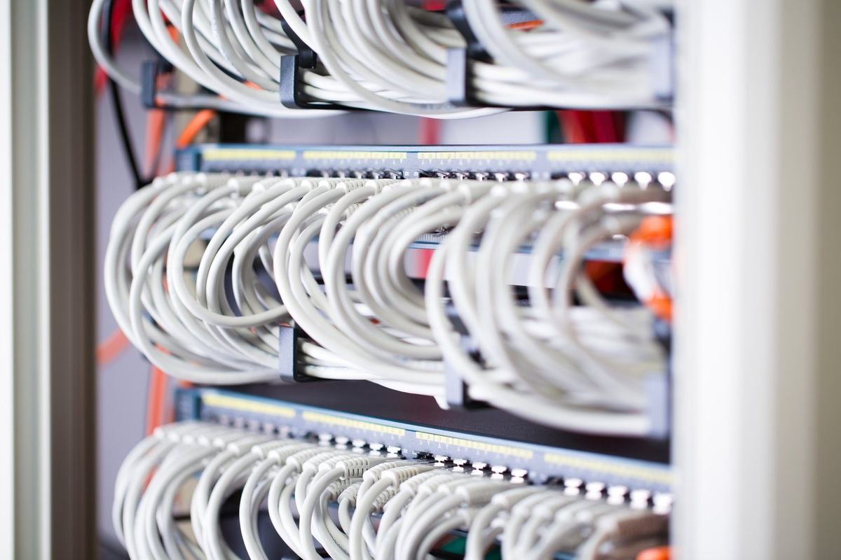 Przełącznik sieciowy i przewody w szafie teleinformatycznej na hali